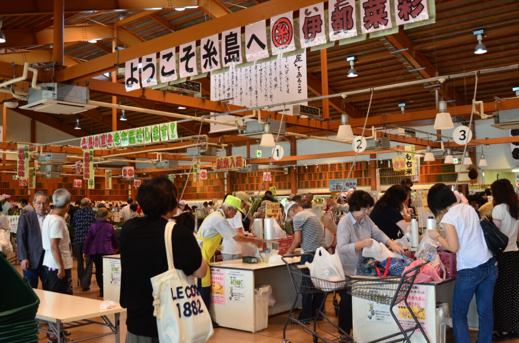 糸島市波多江・JA糸島産直市場 伊都菜彩。9時開店 店内(「ようこそ糸島へ 伊都菜彩」の横断幕とレジ前)