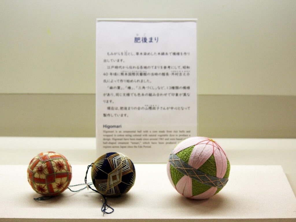Three Higo temari balls in a display case