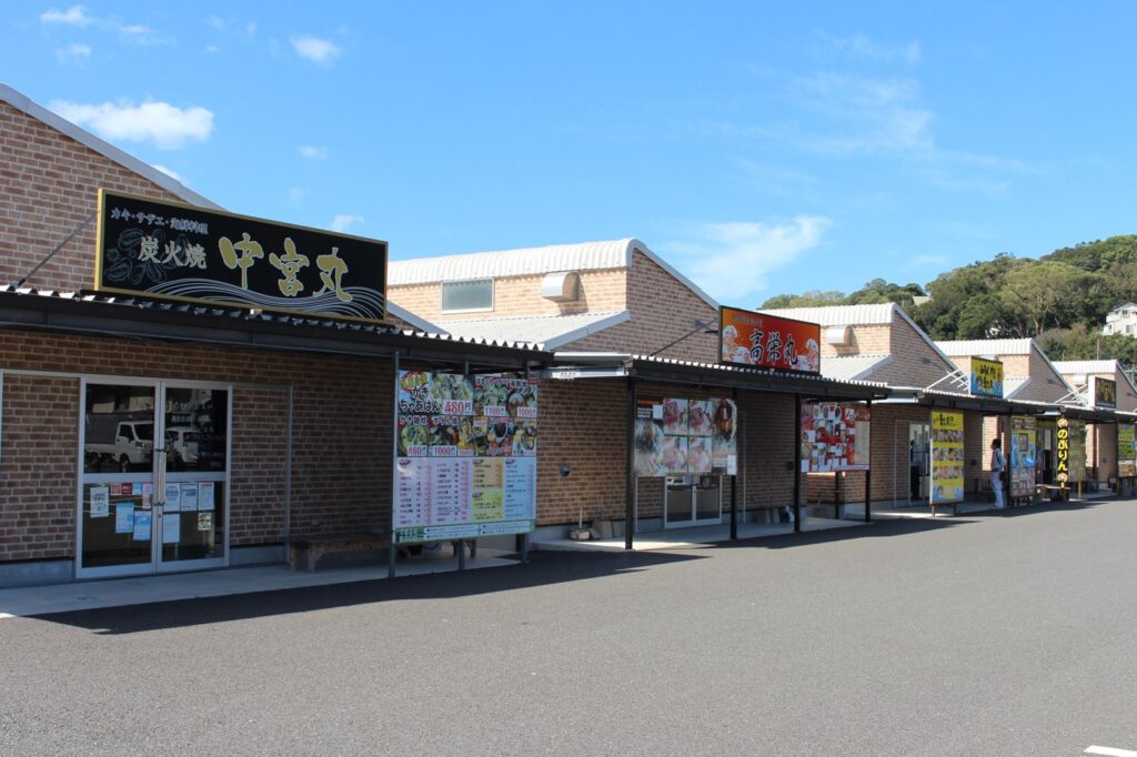 Oyster huts in Itoshima 2026–27: opening dates by port, prices and how to get there from Fukuoka Oyster huts in a row at Kishi port, with the signs of Nakamiyamaru, Koeimaru and Noburin