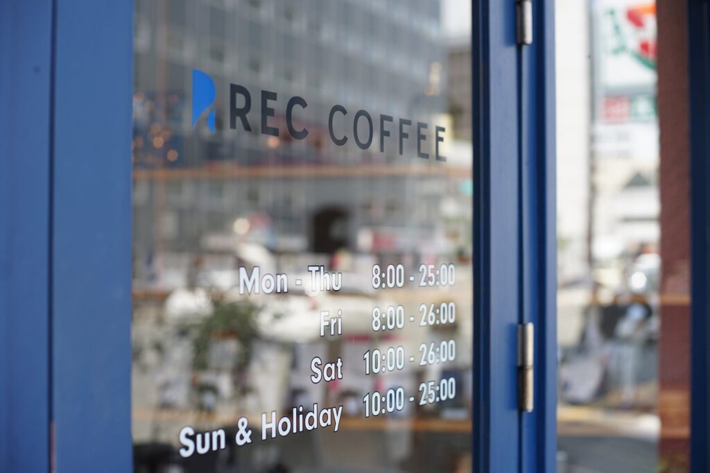 薬院のREC COFFEE 薬院駅前店。夜のコーヒー、深夜24時までの営業と価格 入口の扉（営業時間は撮影時の掲示）
