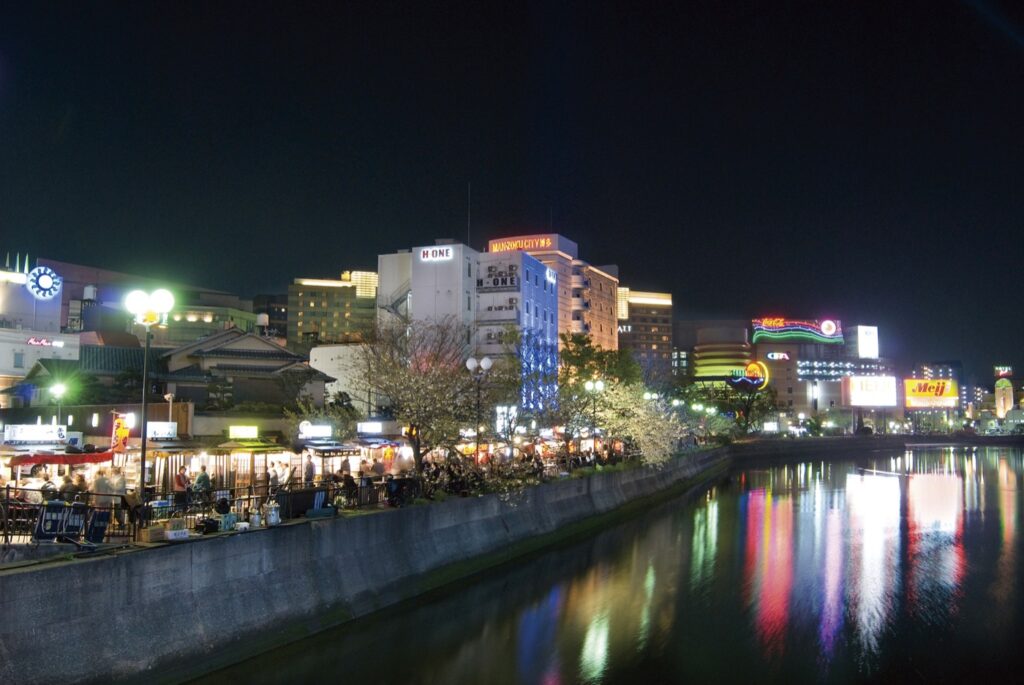 Yatai in Fukuoka for First-Timers: Opening Hours, City Rules and How to Check Prices (2026) Yatai along the Naka River in Nakasu at night