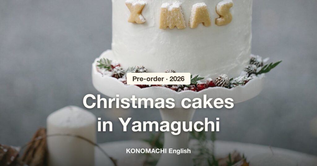 A Christmas cake with XMAS lettering on a white cake stand